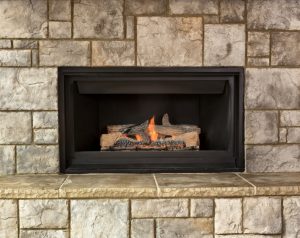 Burning natural gas fireplace surround by stone