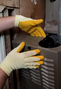 technician's hands working on heater