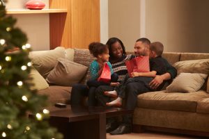 Family Celebrating Christmas At Home Viewed From Outside