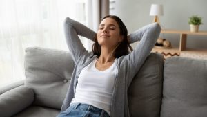 woman-looking-comfortable-in-home-leaning-back-on-couch-with-eyes-closed