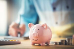 piggy-bank-in-foreground-with-person-budgeting-in-background